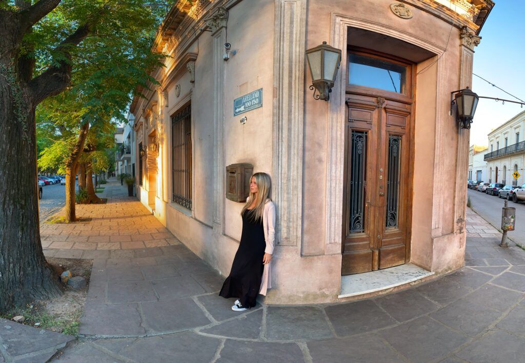 Noeli en una esquina de San Antonio de Areco, apoyada en una construcción tipica del casco histórico