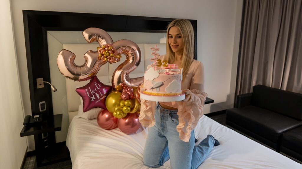 Noelí sobre la cama con una torta y globo por su cumpleaños